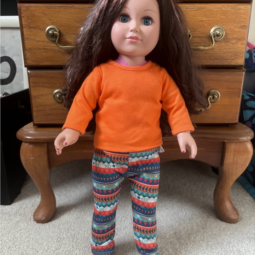Charming Doll with Orange Top and Patterned Pants